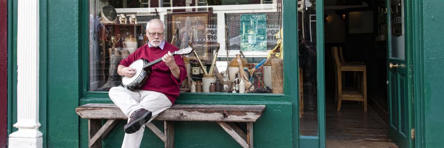 A man outside a pub playing Music. Enjoy musical tour of Ireland with Discover Ireland Tours.